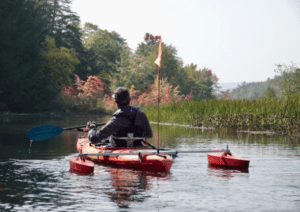 An athlete enjoying adaptive kayaking on the calm water