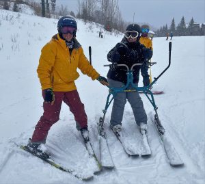 A veteran used the ski slider with Keja MacEwan and Kathy Lockwood of SASC.