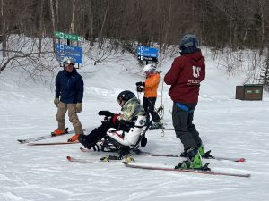 Jack in Tetra Ski with instructors and volunteers