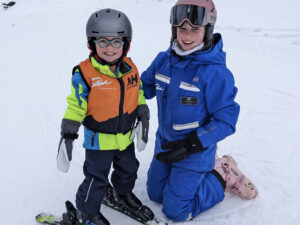 A young skier is all smiles with his Stowe instructor.