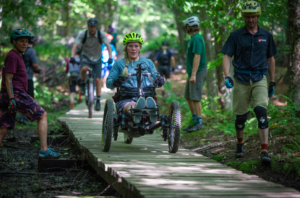 Athlete supported in a bridge by volunteers.PC: Mike Hitelman.